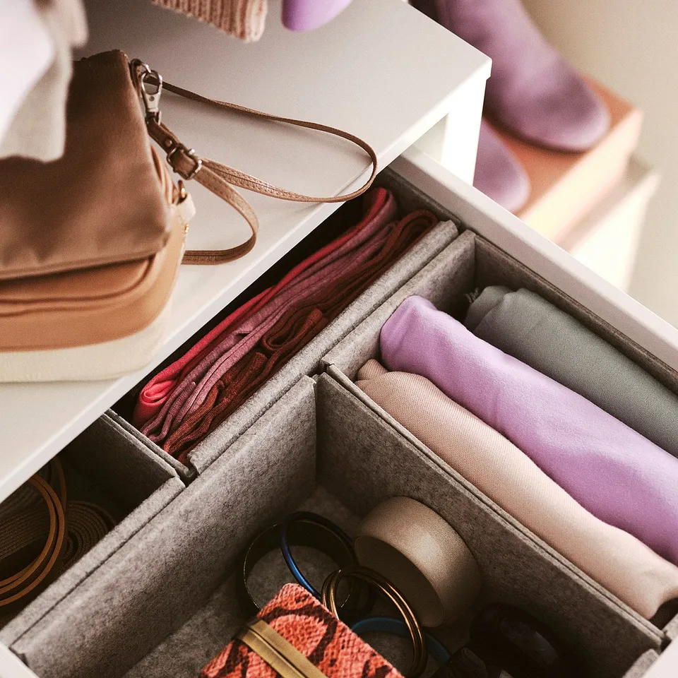 Open drawer with accessories: folds scarves, stores bra, contains purses.