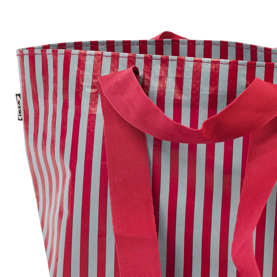 Striped tote bag with red and white lines, sturdy handles, and zip; ideal for carrying items securely.