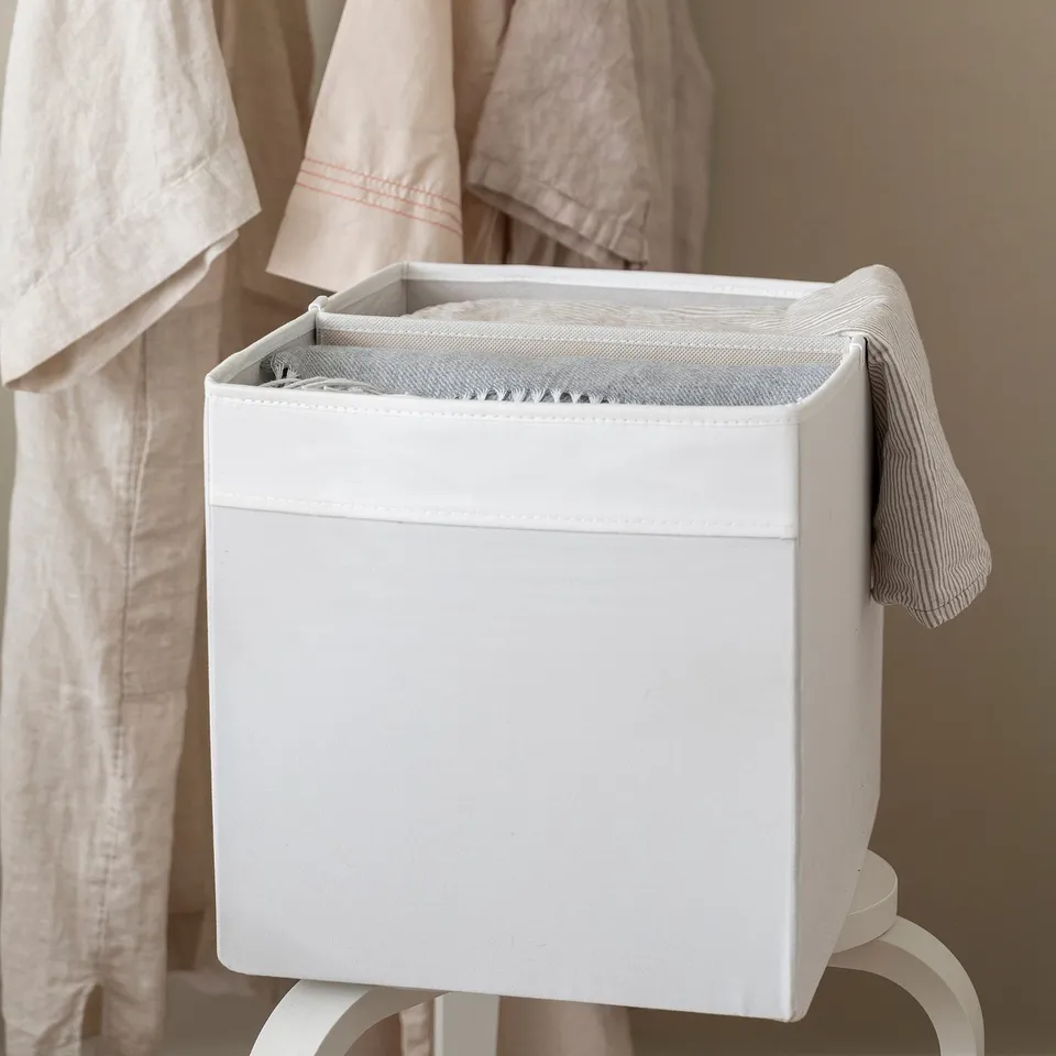 White storage bin with removable divider, organising items into two compartments. Fits inside DRÖNA box.