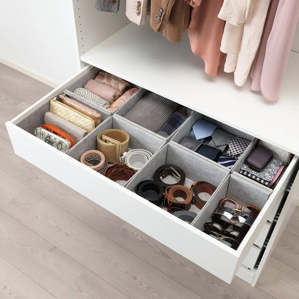 Open wardrobe drawer showing organised compartments for accessories like belts, ties, and purses, customizable with felt boxes.