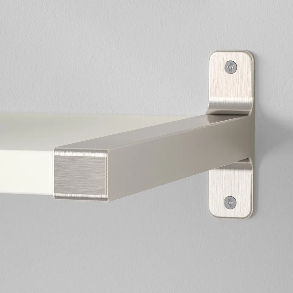 Silver metal shelf bracket mounted on a grey wall. High-quality finish, securely fastened with visible screws.