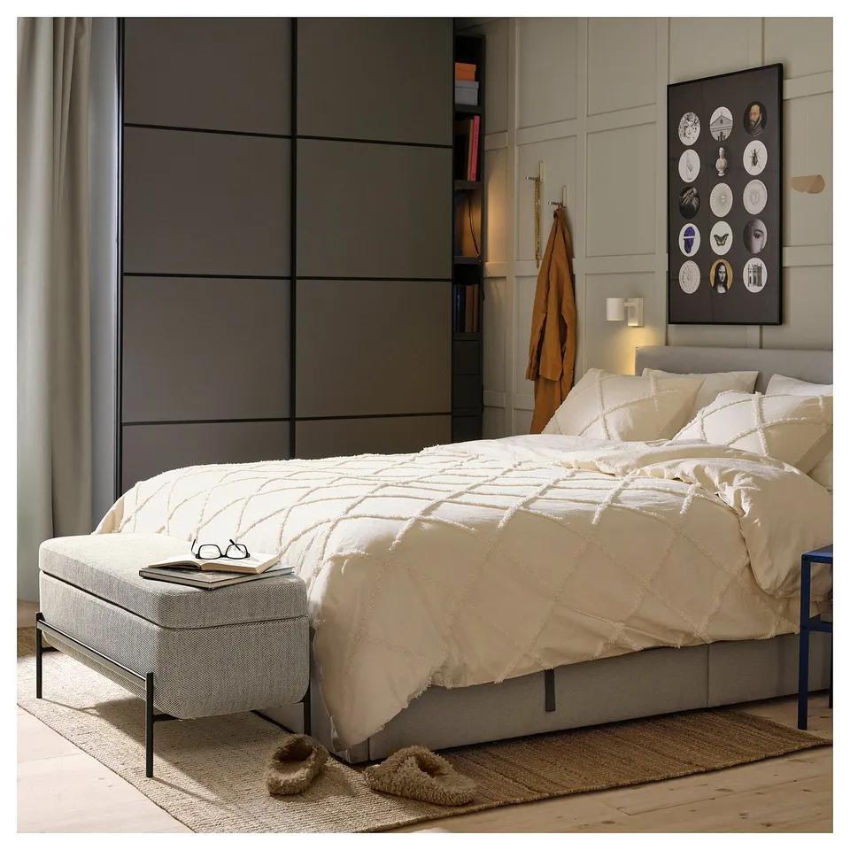Modern bedroom with a beige VALTORP bed, white bedding, and a cosy atmosphere.