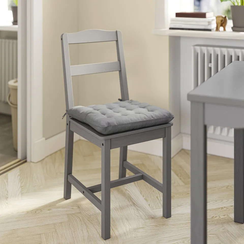 Grey vippart chair pad on wooden chair.