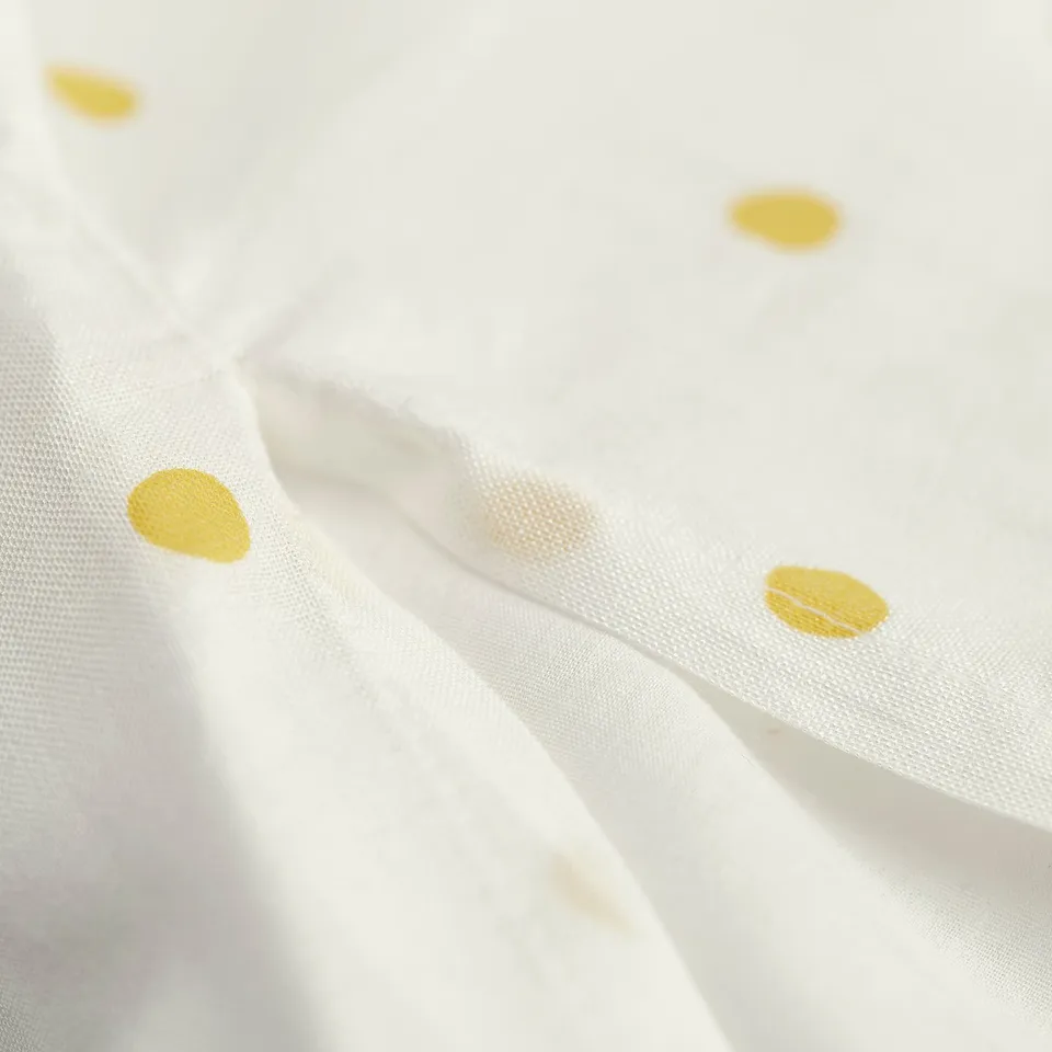 White fabric with small, spaced yellow dots. Appears suitable for young children, aged 3+.