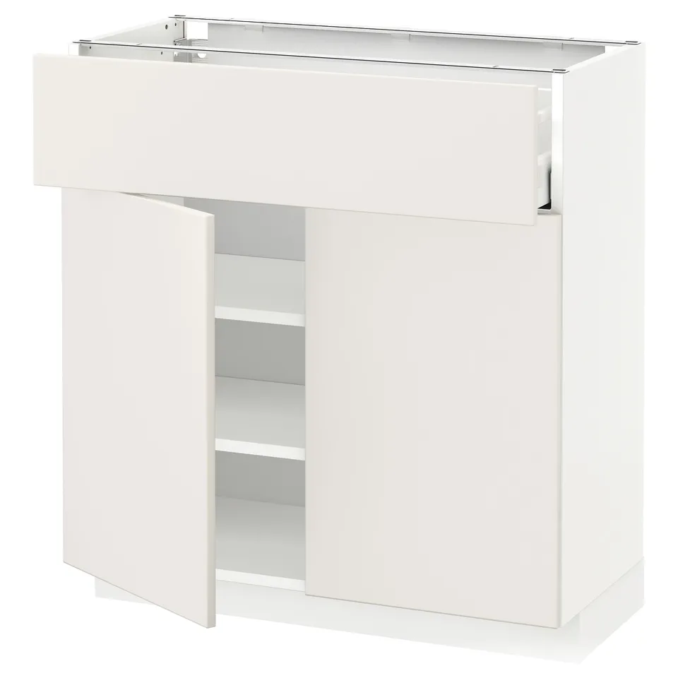 A white METOD kitchen cabinet with veddinge fronts. It has a sleek, modern design with one open door revealing adjustable shelves.