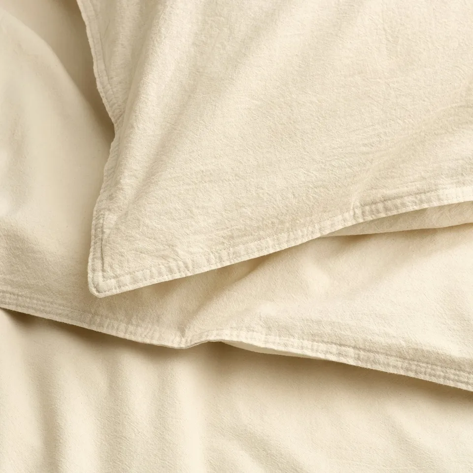 Soft, natural cotton detail of folded bedding. Pre-washed for softness, breathable witha smooth texture.