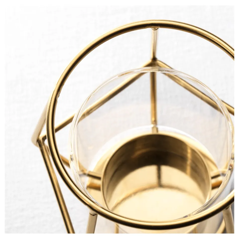 Clear glass tealight holder with golden metal frame. Elegant and sturdy design, sits steadily on any surface.