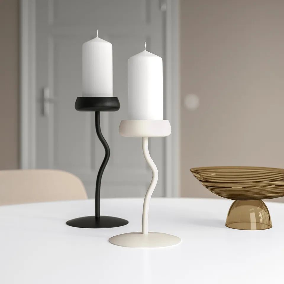 Modern, minimalist candlesticks in black and white, inspired by flower stems. Displayed on a table, contrasting in size with a small golden bowl.