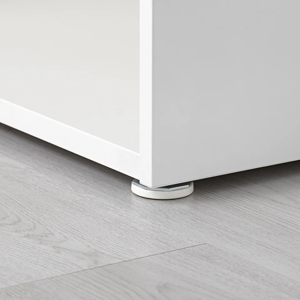Close-up of adjustable furniture leg on wooden floor. Glossy white leg with metal base ensures stability.