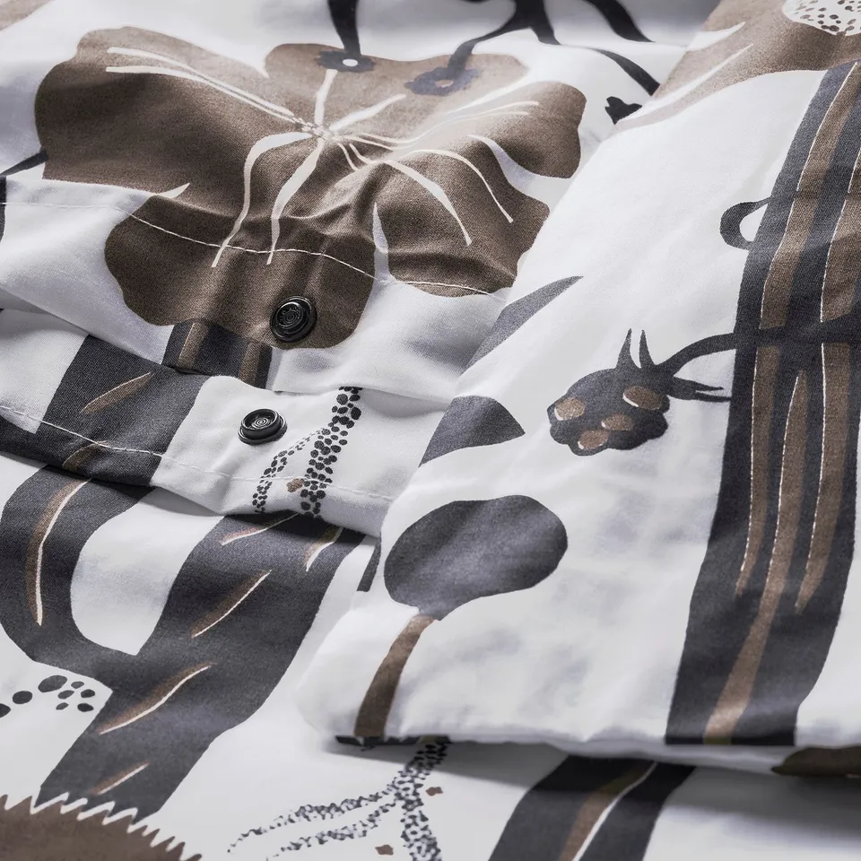 White duvet cover with abstract flower pattern, button closure at bottom, crisp percale texture.