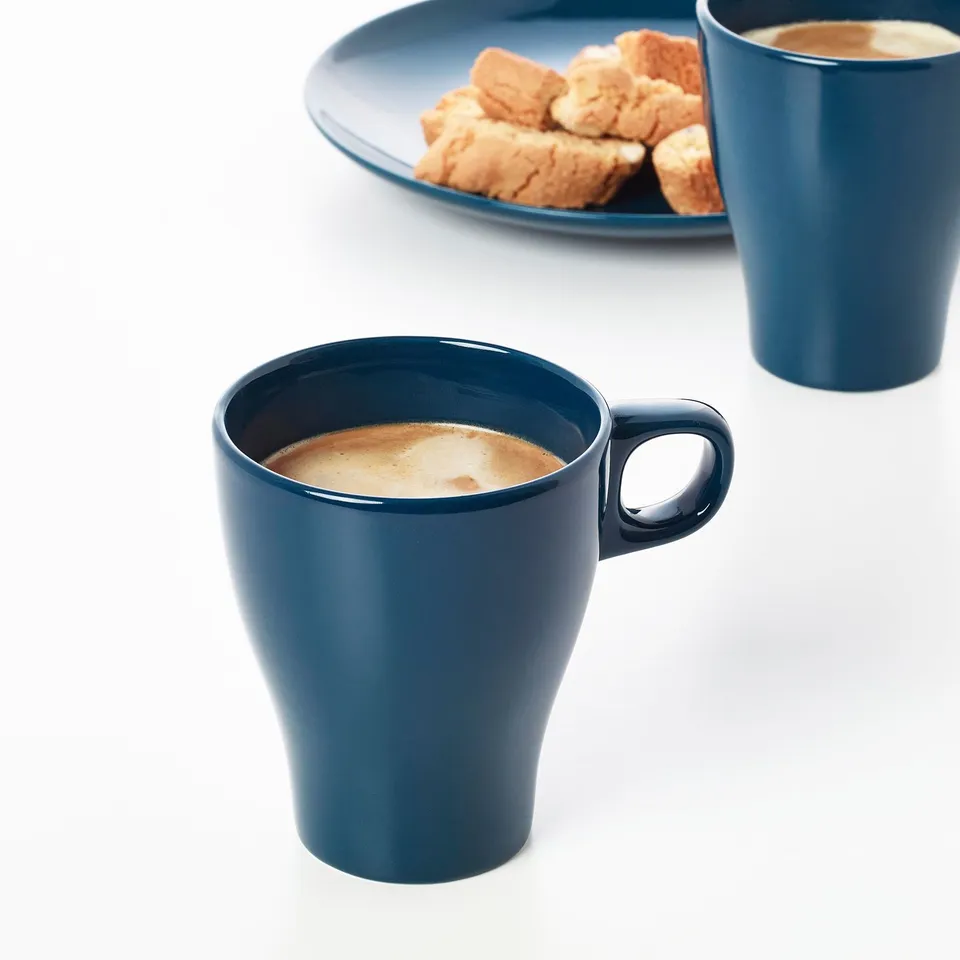 Teal mugs with coffee, biscuits on plate, dishwasher safe.