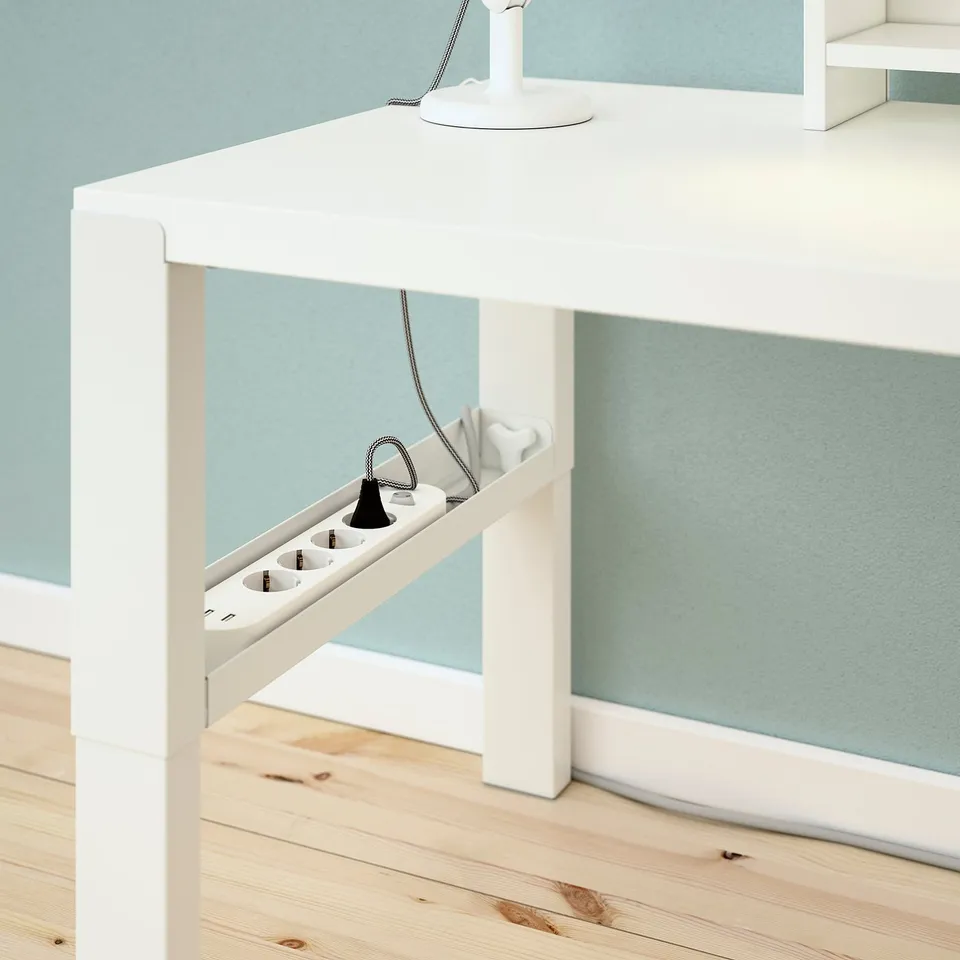 White desk with adjustable height, cable trays visible.