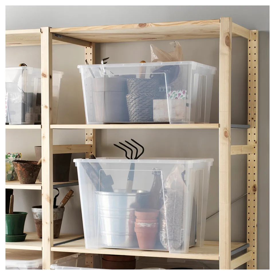This image SAMLA storage boxes on wooden shelves. Transparent plastic boxes hold various items, neatly organised.