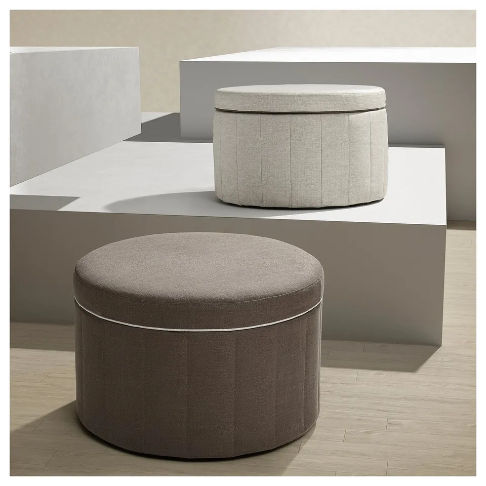 Two round storage ottomans: one beige, one brown, with pleated sides and lids, on a modern, minimalist platform.