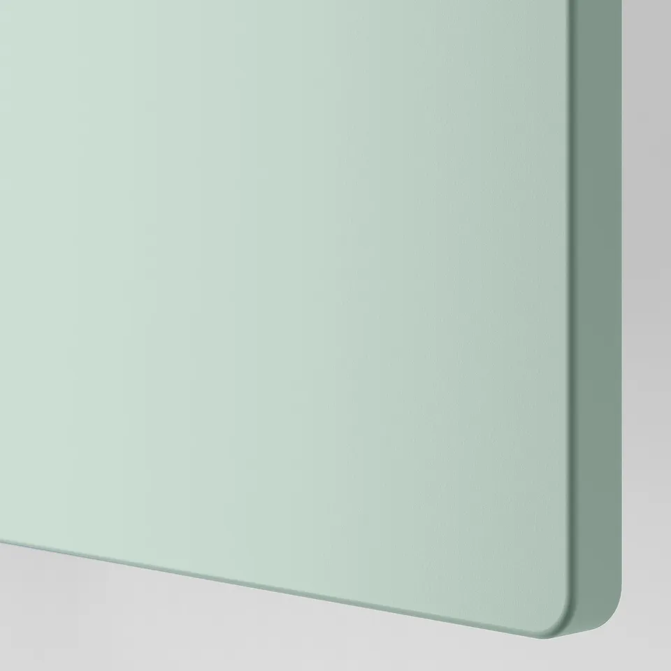 A close-up of a smooth, light green surface, likely a drawer front, showcasing its sleek and modern design.