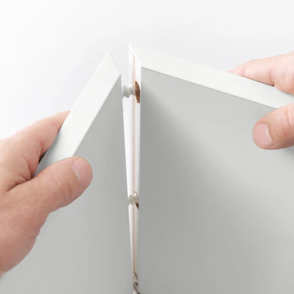 Hands assemble EKET wall-mounted storage cabinet, showcasing its modular and space-saving design.