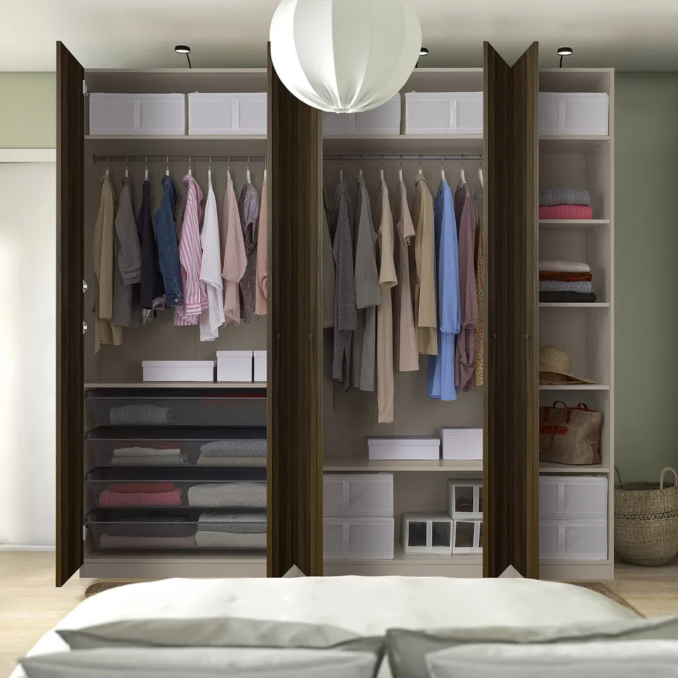 Organised bedroom with open wardrobe showcasing clothes and storage boxes.