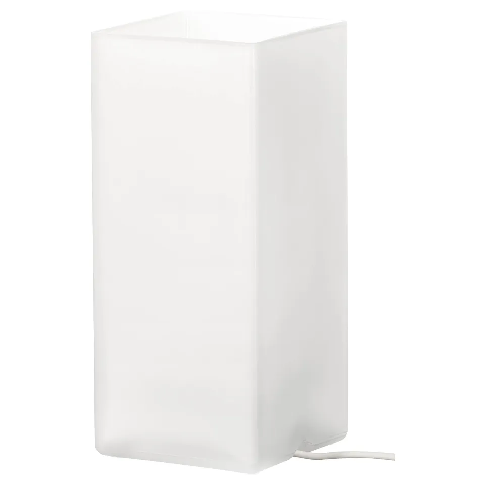 A white GRÖNÖ table lamp with a frosted glass shade. It has a minimalist design, emitting soft light for a cosy ambiance.