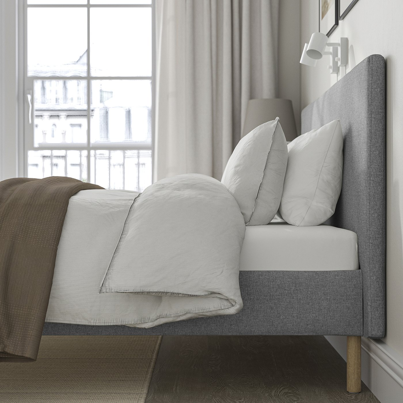 Modern bed with grey headboard, wooden legs, near window, clean, comfortable.