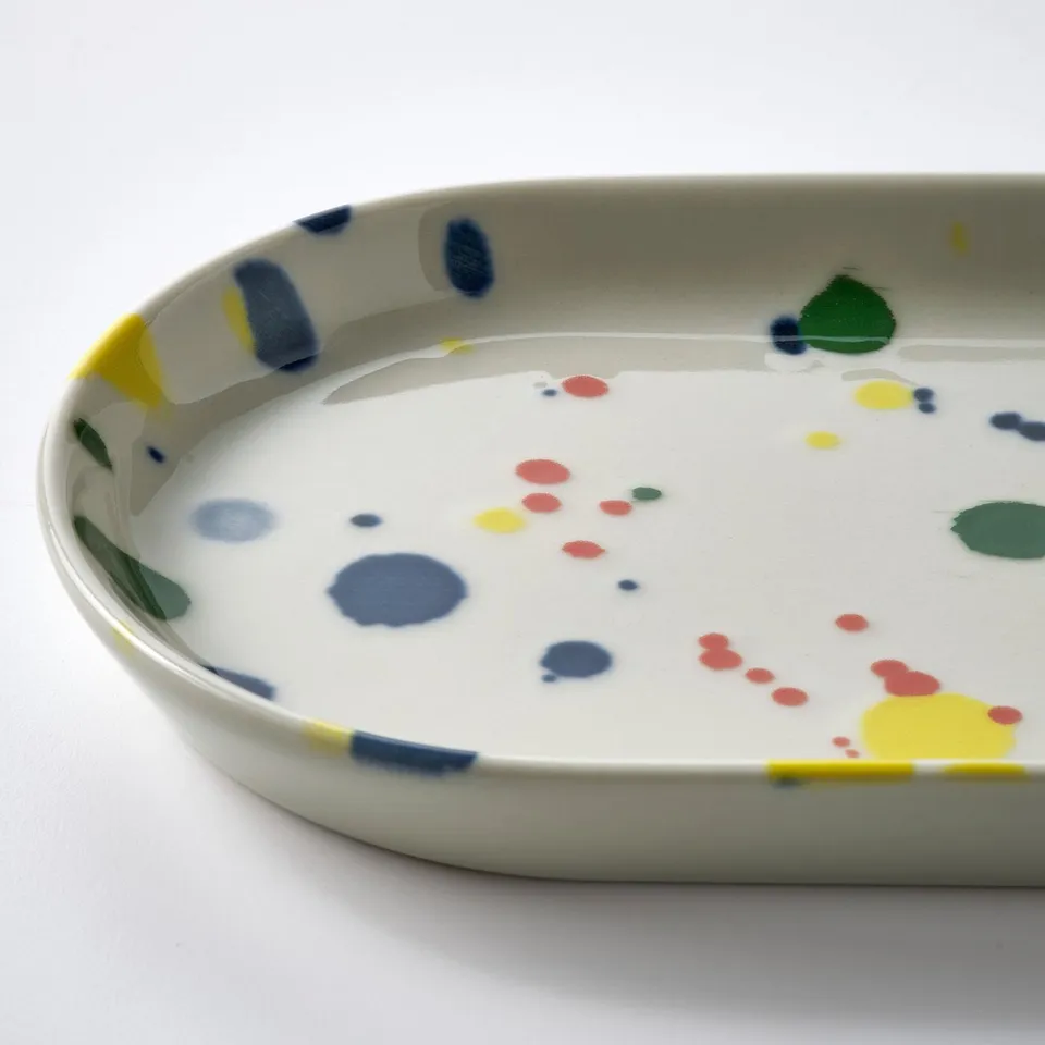 White oval serving tray with colourful splatters.