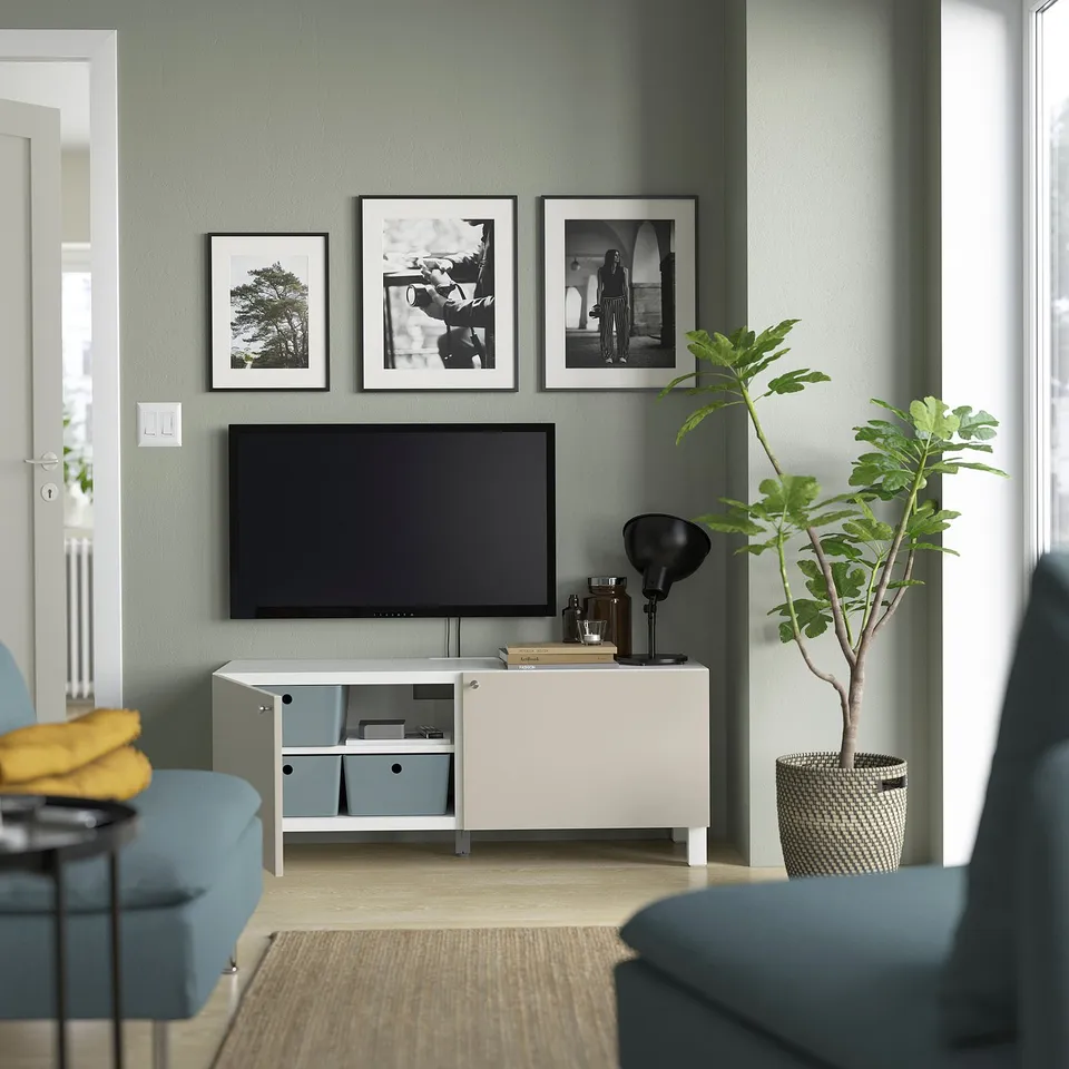 Modern living room with BESTÅ tv stand, plant, & cosy seating.