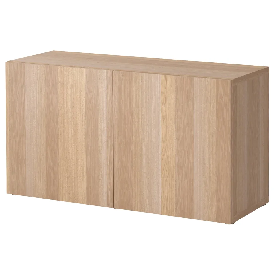 A BESTÅ wooden cabinet in light oak. The cabinet has two doors with a rectangular shape and minimalist design.