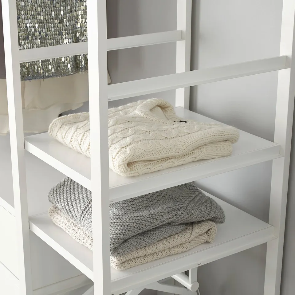 Folded sweaters on white ELVARLI shelves, easy to move and organise.