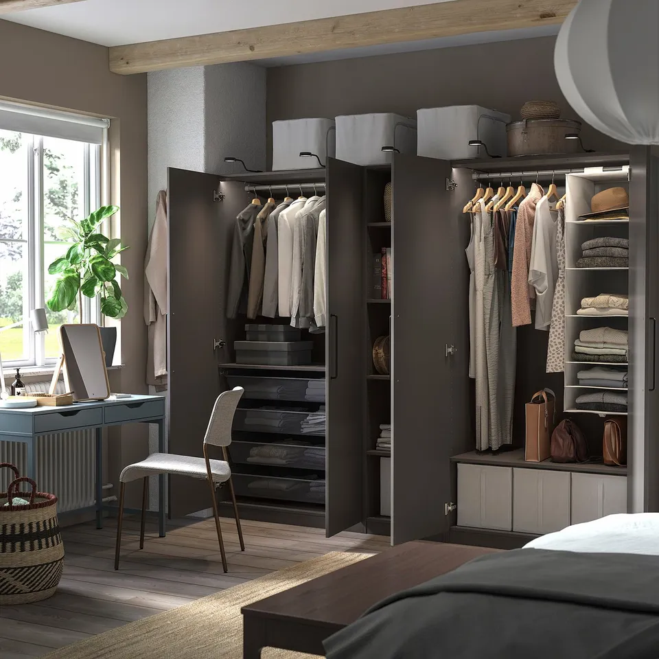 Modern bedroom black PAX wardrobes with clothing and storage solutions, including shelves and drawers.