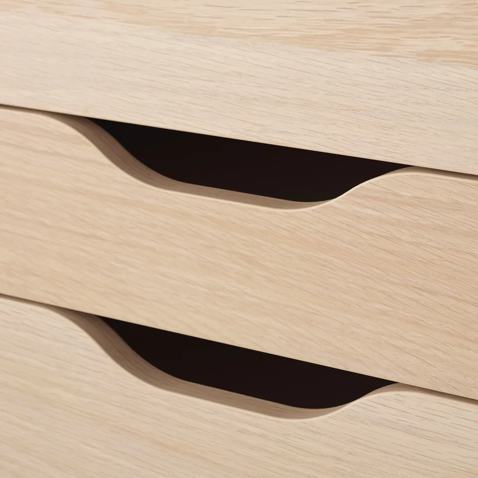 Close-up of light wood drawer handles, showcasing smooth, rounded design and quality craftsmanship.