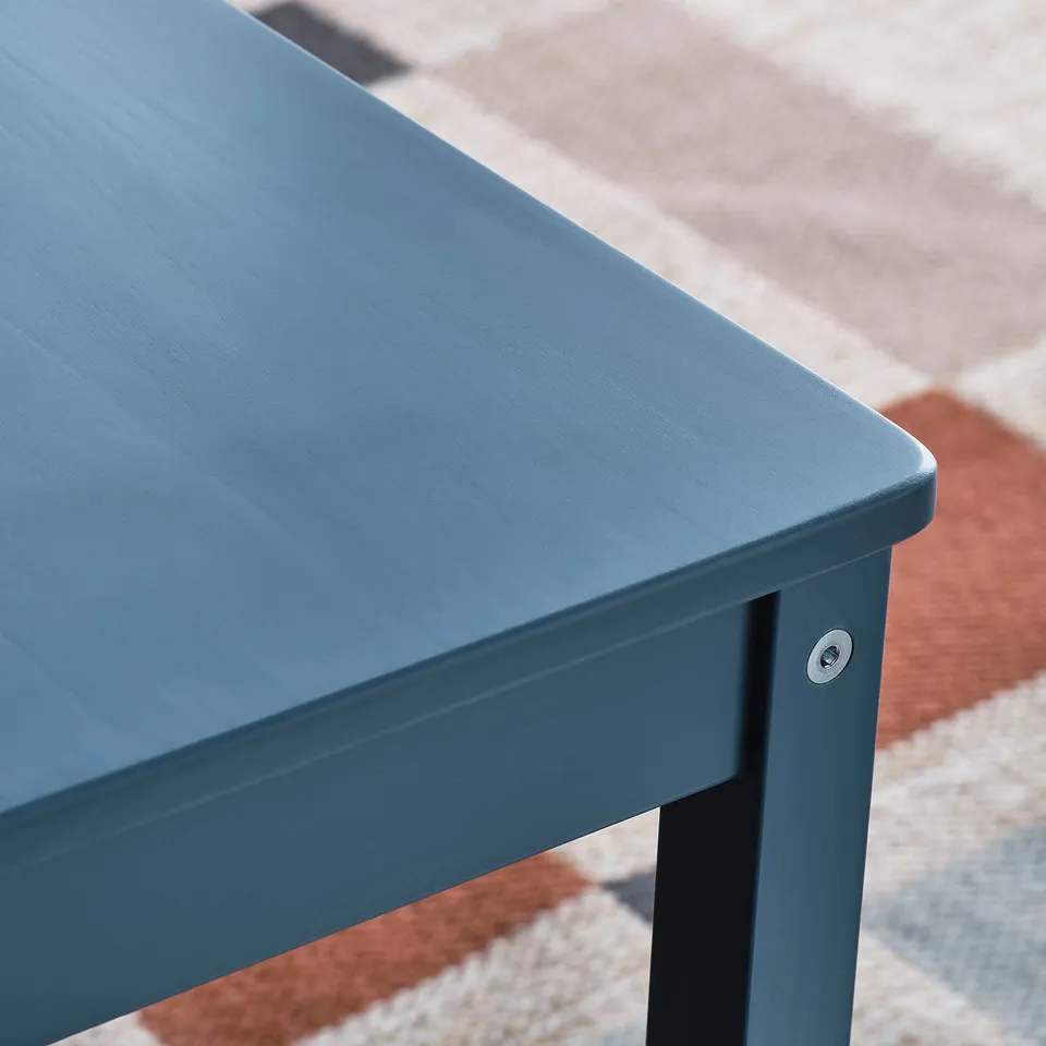Blue wooden table with rounded edges and metal connector visible.