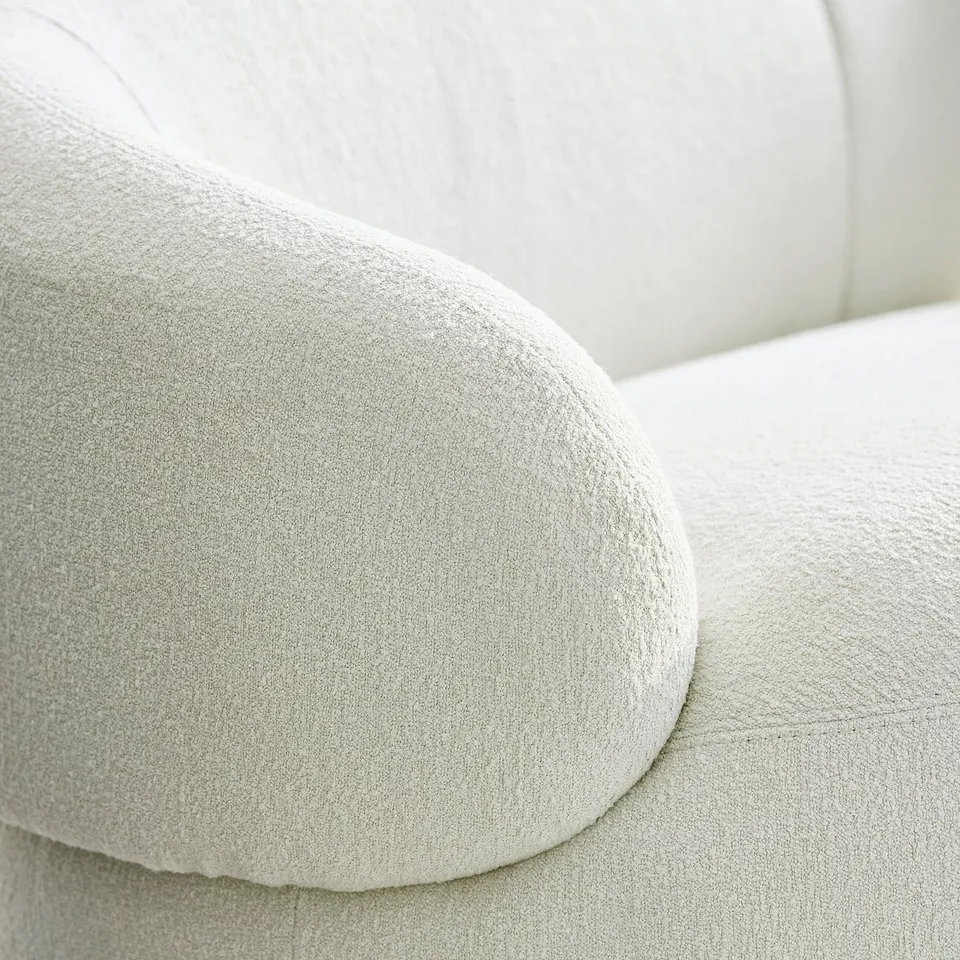 Close-up of plush, white, textured upholstered cushions, showcasing high-quality sofa design.