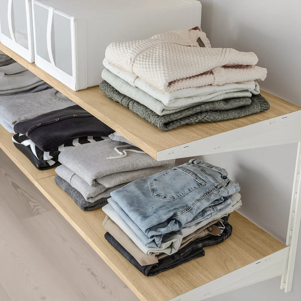 Shelf organiser with neatly folded clothes, maximising storage space.