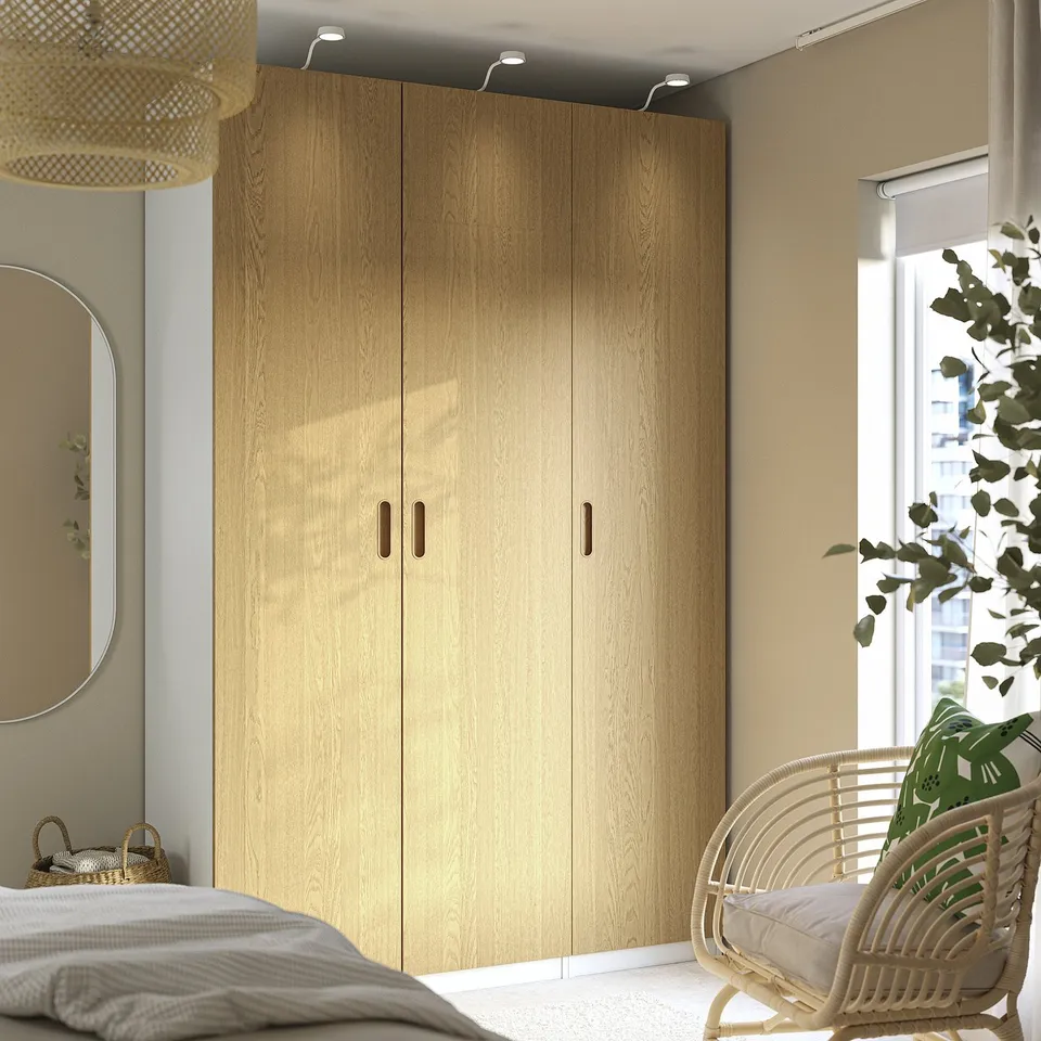 Modern bedroom with TONSTAD oak wardrobe and wicker chair.