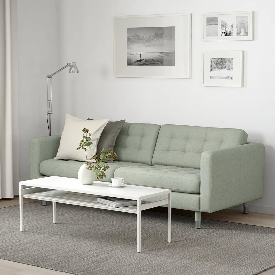 Modern green 3-seat sofa LANDSKRONA with cushions & tight-fit cover. Its the focal point in a minimalist room with wall art and a coffee table.