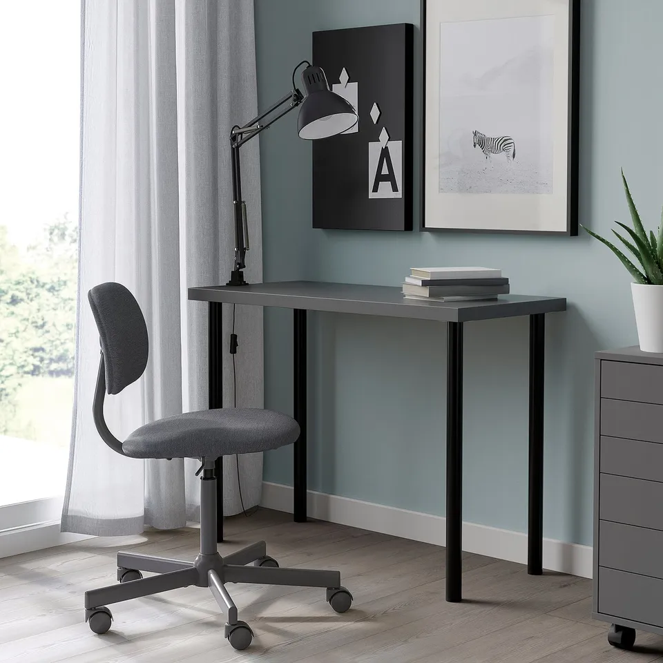 Grey LINNMON desk with chair against blue wall, lamp, art.