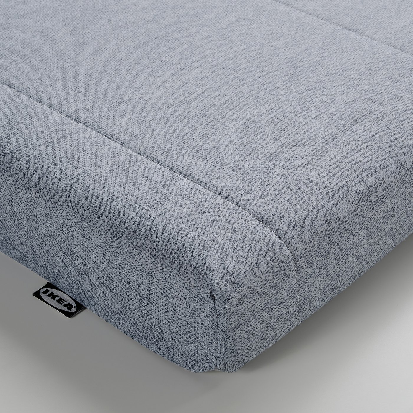 Close-up of a grey foam mattress on a white background, showing its texture and quality.