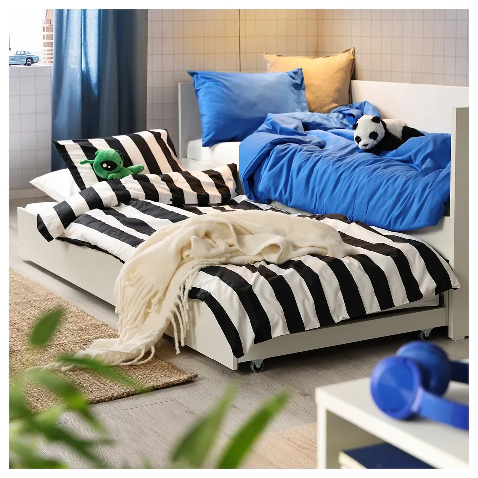 Cosy bedroom featuring a white VIHALS daybed with trundle, striped black and white linens, blue pillows, and plush toys.