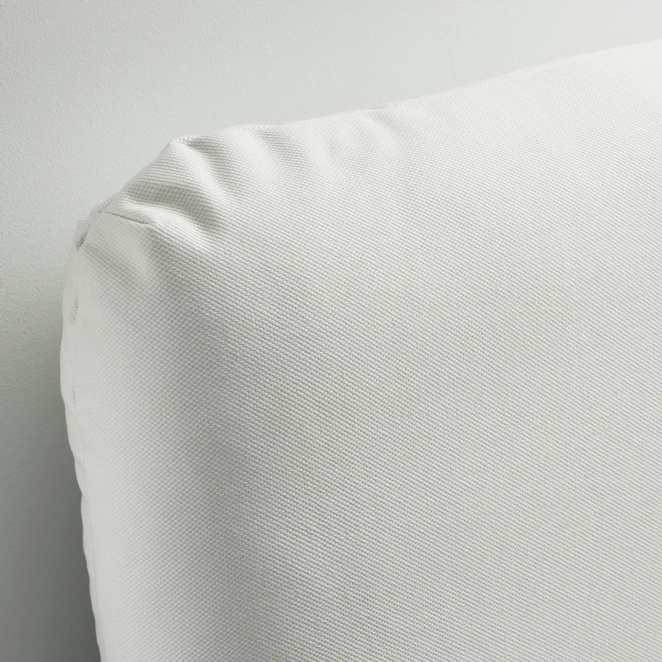 A corner of a white upholstered bed frame, showcasing its smooth, machine-washable fabric and sturdy design.