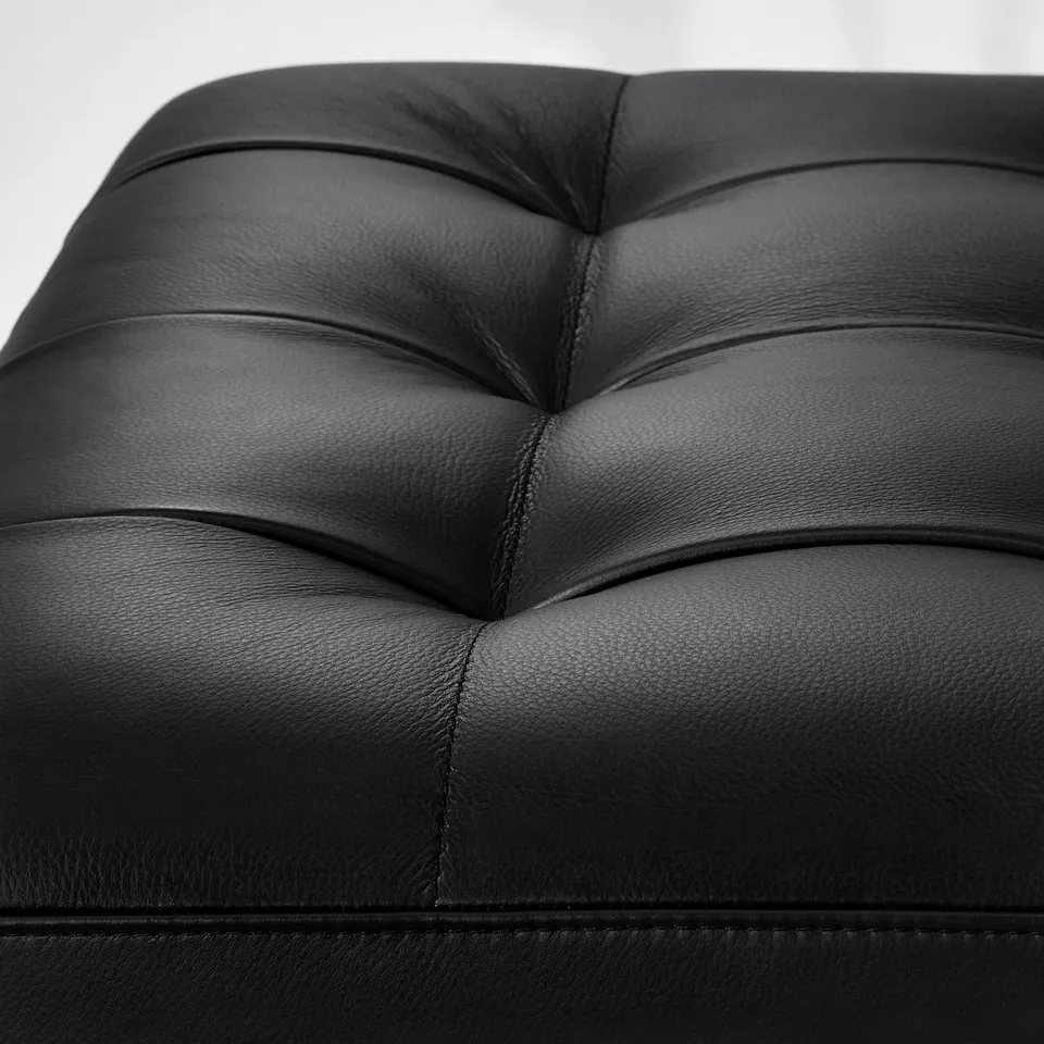 Black leather seat detail, showcasing smooth surface and stitching.