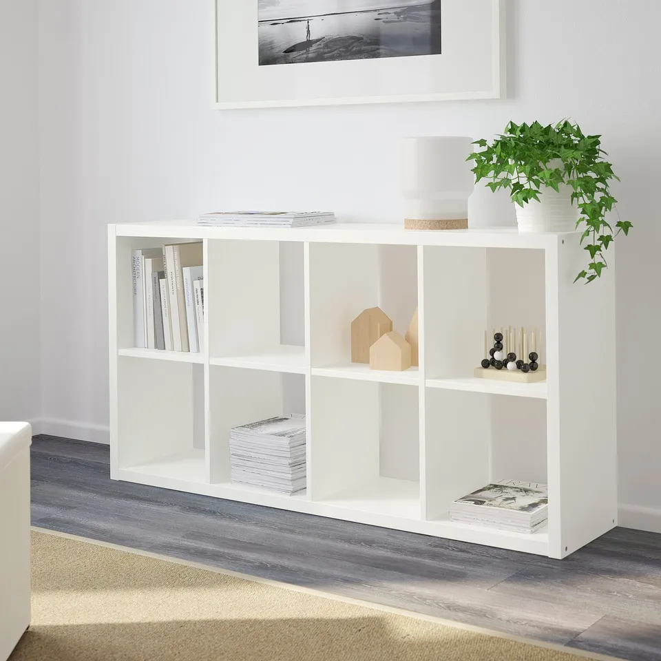 White FLYSTA shelf with books, plant, decor.