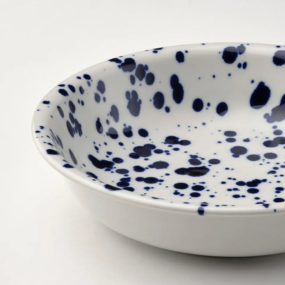 White bowl with scattered blue spots, smooth glaze, elegant texture