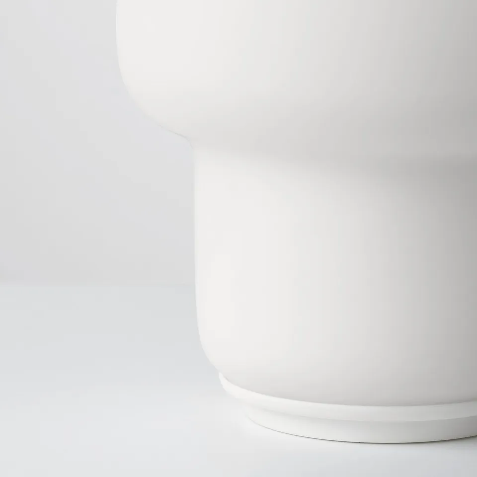 Clean, minimalist table lamp with smooth, rounded glass shade and sturdy base, perfect for modern decor.