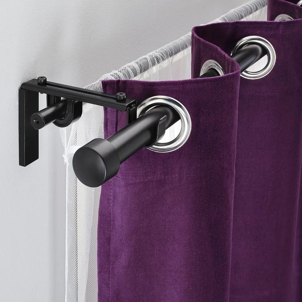 Purple curtains hang from a double rod system on a black bracket, allowing two layers of curtains.
