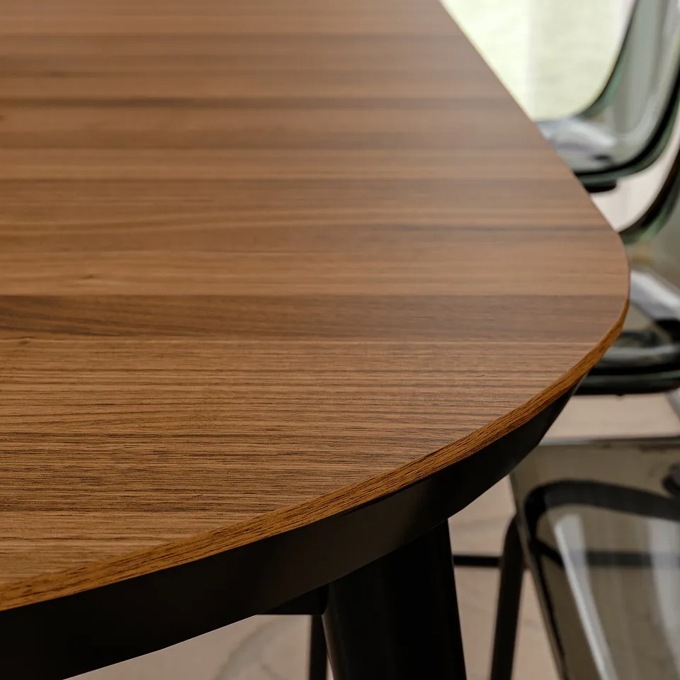 Round wooden table with smooth, polished surface and dark edges, set on a metal base.