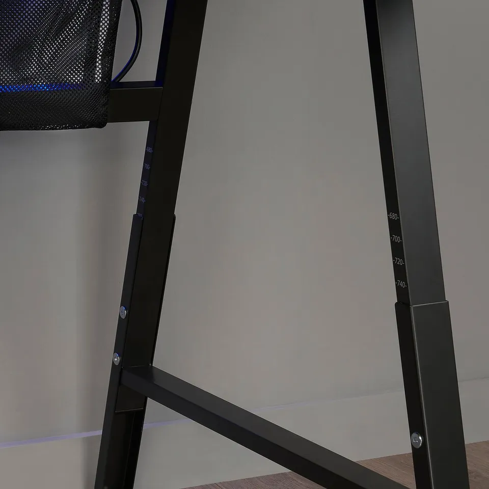 A black UTESPELARE gaming desk with adjustable height legs, marked with measurements, and a mesh area for cable management and pc ventilation.