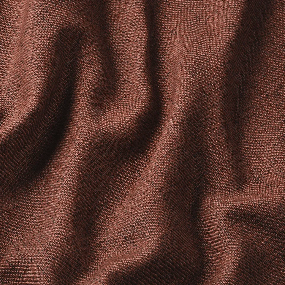 Close-up of soft, textured red fabric with subtle melange effect, showcasing its quality.