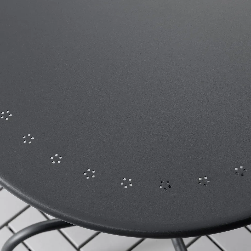 Black round outdoor table with drain holes, sleek powder-coated steel surface.