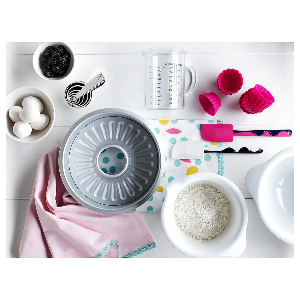 A baking setup: tools, ingredients, and bundt pan on white.