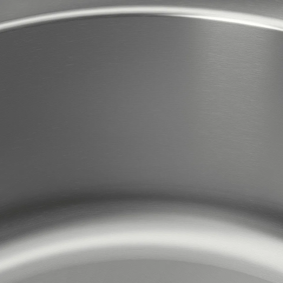 Stainless steel sink close-up, smooth texture, sleek surface reflecting light, emphasising quality and durability.