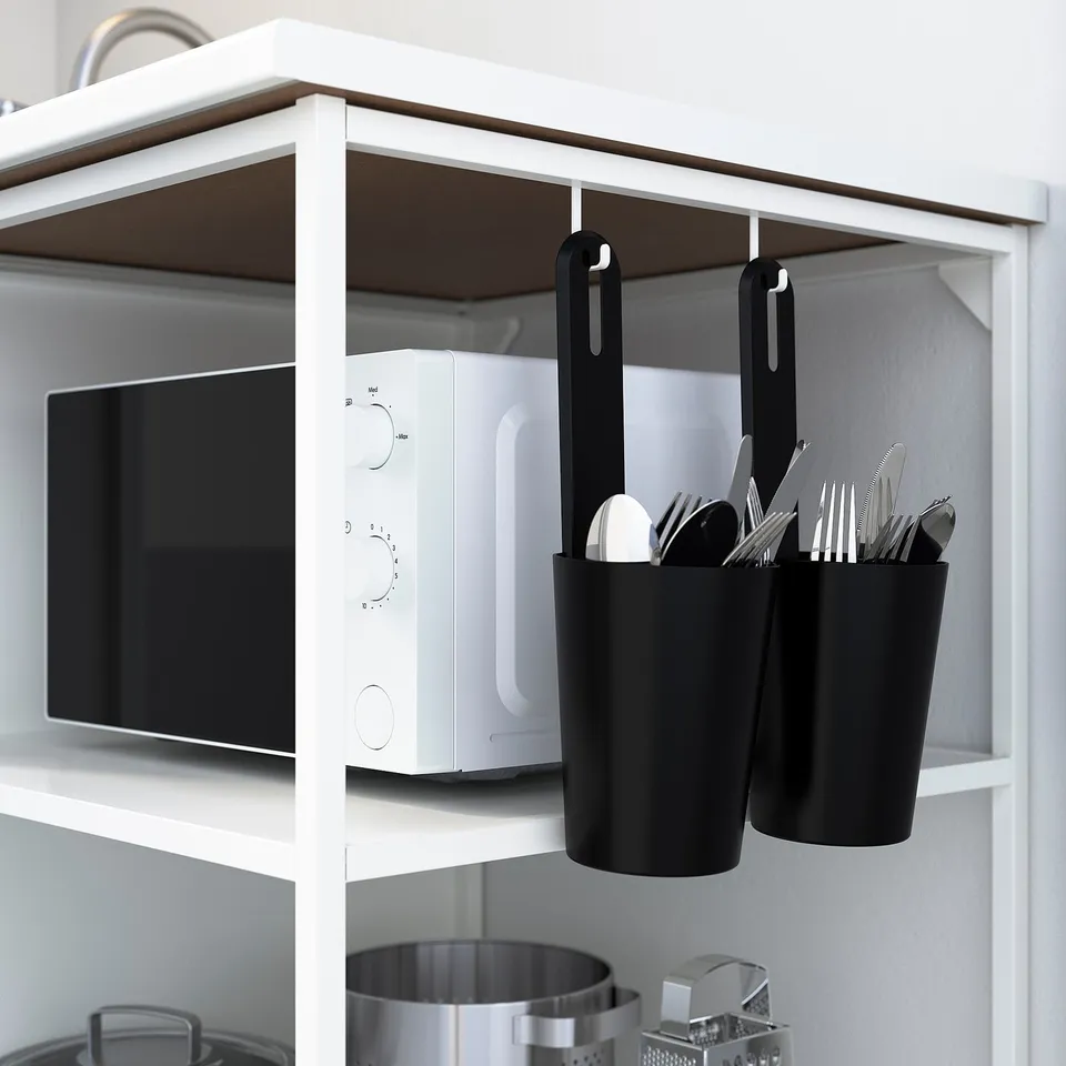 White kitchen shelf with microwave, hanging utensil holders.